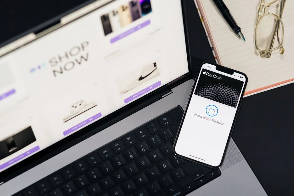 A woman makes an online purchase using a credit card on her laptop, browsing an online fashion store.