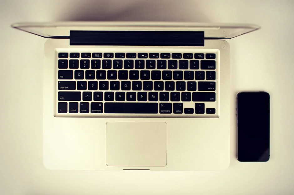 Close-up of woman shopping online using a credit card on a laptop.